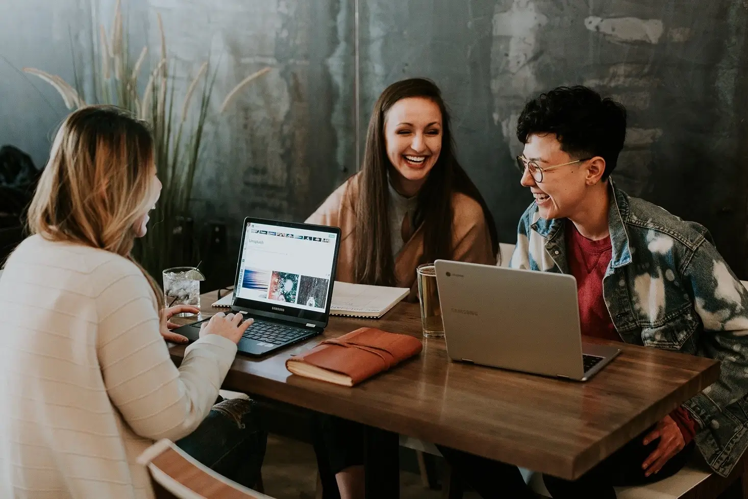 group of people with laptops laughing