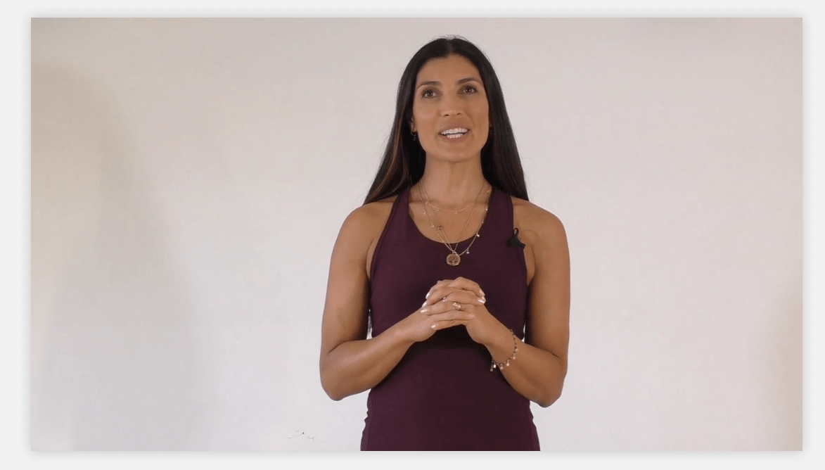 A screenshot showing a female yoga instructor talking in a video.
