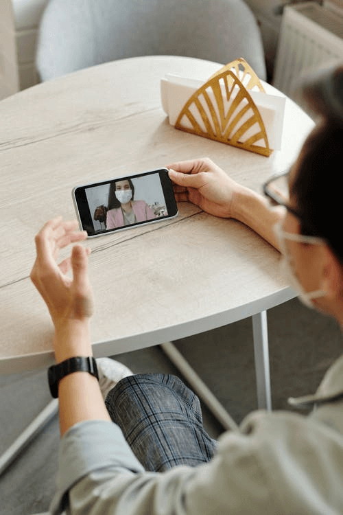 Picture showing a student watching a webinar through a mobile phone