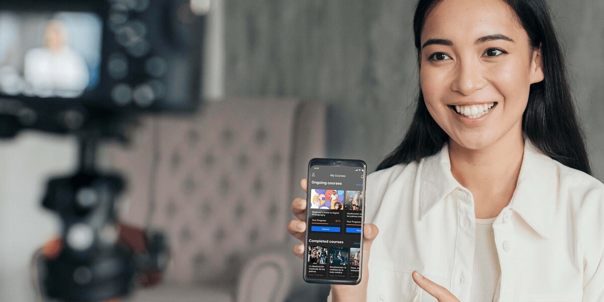 Woman showing her no-code lms app on her smartphone.