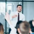 man wearing tie teaching a group of people