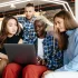 young people gathered around laptop