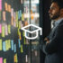 An image showing a man in a suit standing with hands crossed, looking at a wall with colourful post-its.