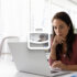 An image showing a woman looking at a laptop screen while at the office and a white briefcase icon in the centre.