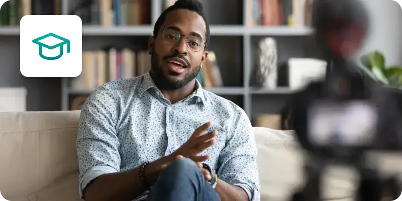 An image showing a man wearing glasses talking in front of a camera.