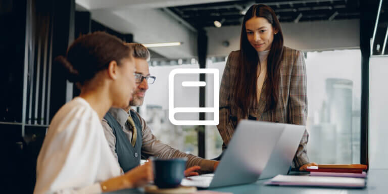 Alt-text: An image showing three people working together at an office.