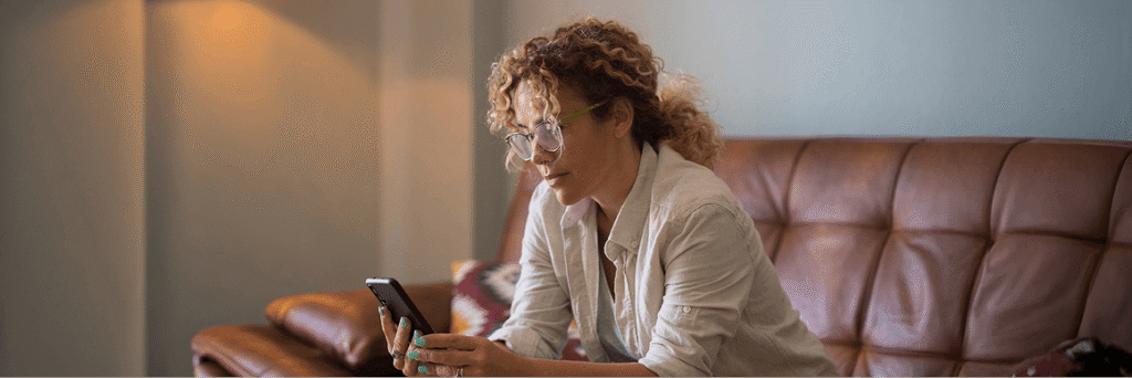 Person sitting on a couch using a laptop in a living room.