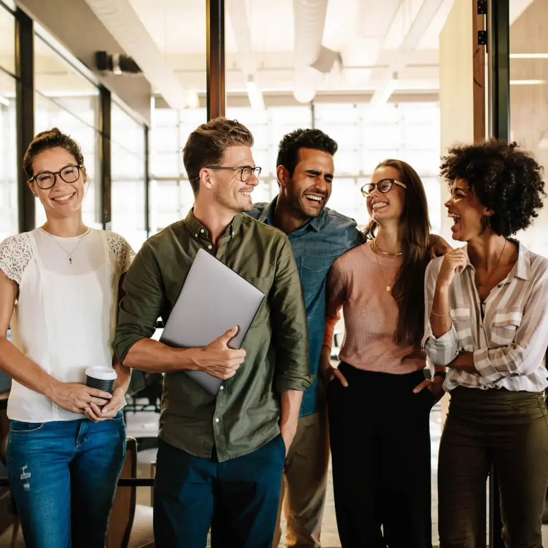 Group of professionals walking and talking in a modern office corridor.