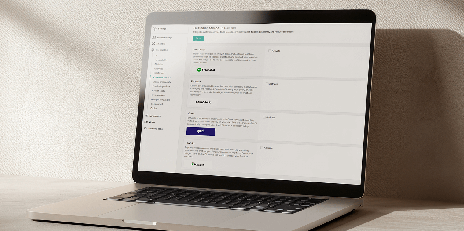 A laptop showing the LearnWorlds dashboard and its integration options on screen.