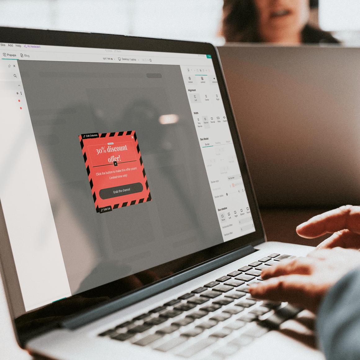 User creating a marketing pop-up banner using the LearnWorlds pop-up builder on a laptop.