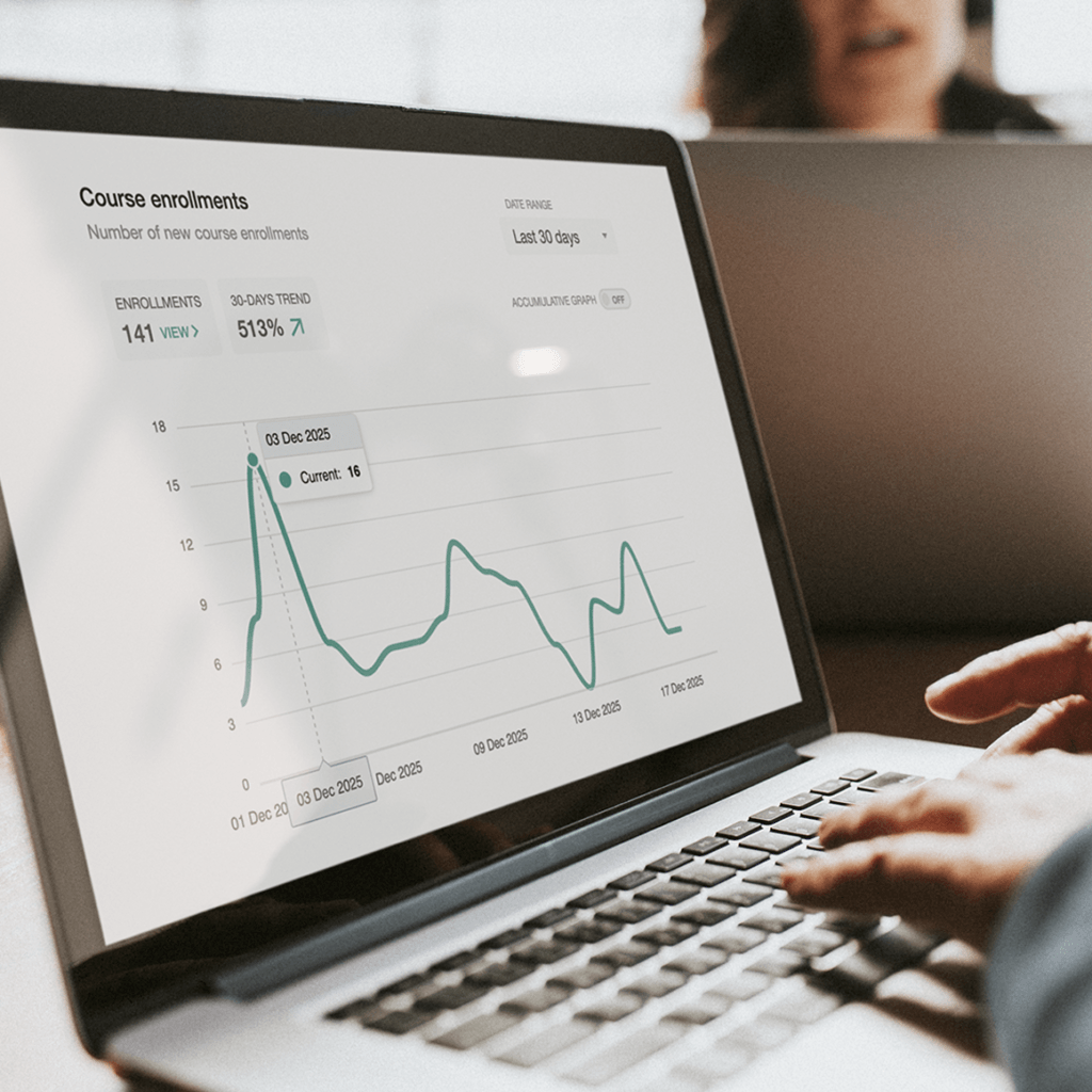 Person using a laptop showing a line chart and analytics dashboard on screen.