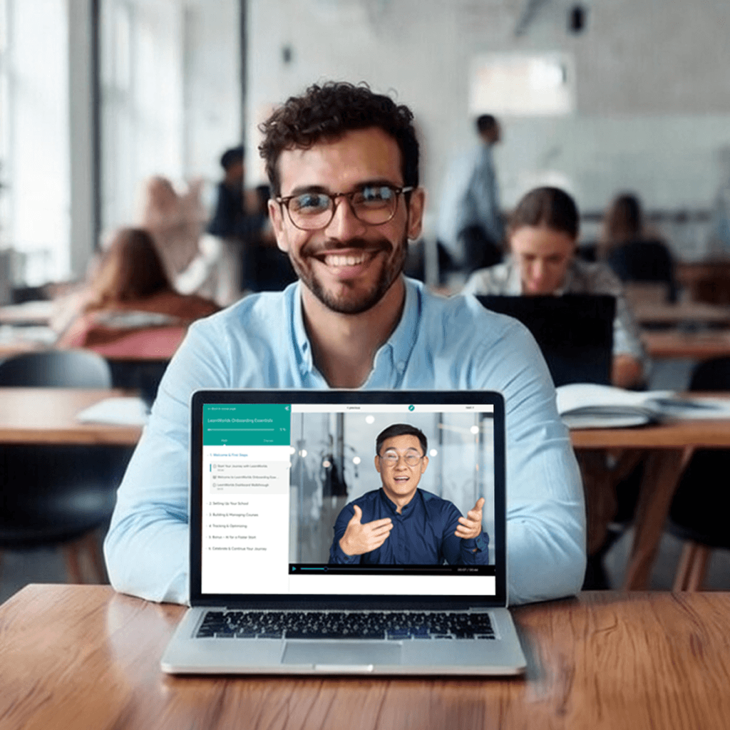 Smiling professional sitting at a desk with a laptop open in the foreground.