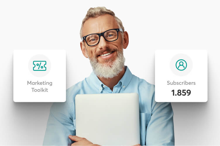 Hombre con un portátil junto al kit de marketing y el número de suscriptores de su academia en LearnWorlds.