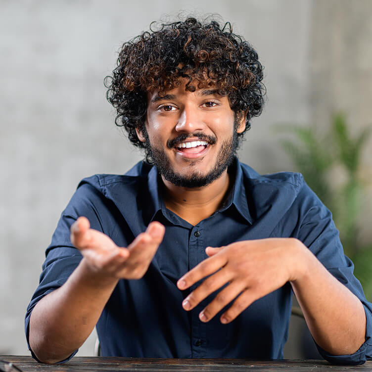 Hombre sonriendo y gesticulando mientras habla a cámara.
