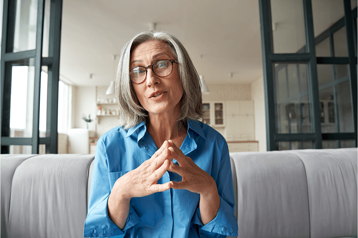 Mujer con gafas hablando a cámara desde el salón de su casa.