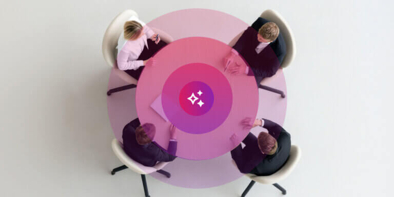 An image showing four people sitting around a circle table and an AI icon in a purple circle in front.